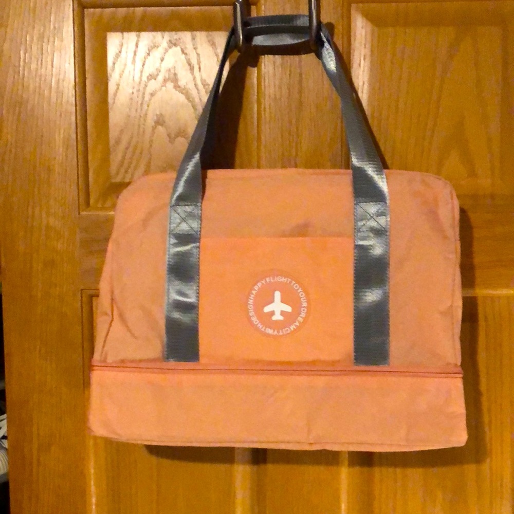 Small salmon colored carry on bag